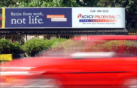 A vehicle passes a life insurance bill board of Prudential-ICICI in Mumbai.