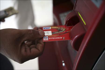 A customer uses his card to withdraw money from an ATM.