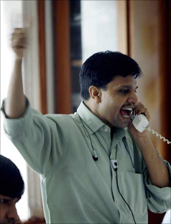 A happy investor reacts as he speaks on the phone.
