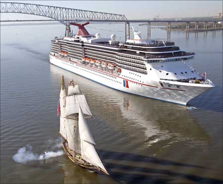 The historic sailing vessel Pride of Baltimore, (L), fires a cannon salute to the Carnival Pride.