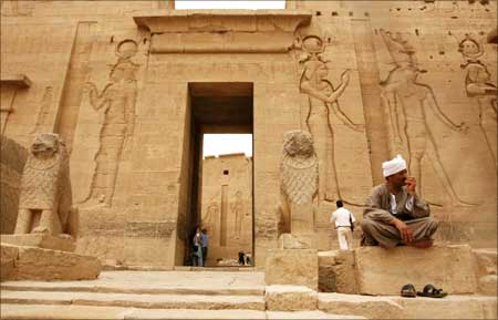 A guard (R) sits inside Fiela Temple in Aswan, Egypt.