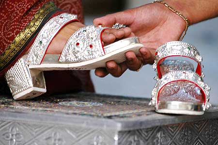 A customer tries sandals made from silver, with wooden soles, in the northern Indian city of Lucknow. Nearly 225-300 grams of silver are used on each pair.