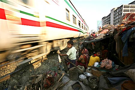 A family takes shelter in their home next to a railway track as a train zips by.