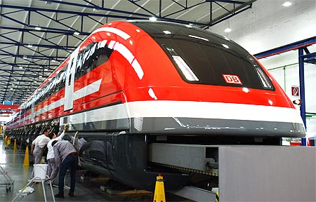 Workers polish a prototype of the new maglev Transrapid high-speed train in German city of Kassel.