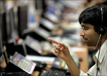 A stock broker monitors indices during trading hours at a brokerage firm in Mumbai.