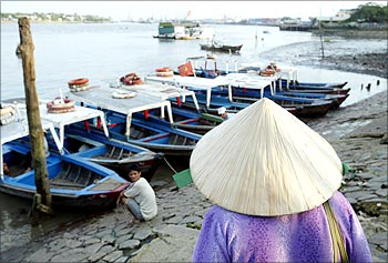 A Vietnamese woman prepares to board a small ferry used to shuttle commuters across the Saigon River near the port in Ho Chi Minh City.