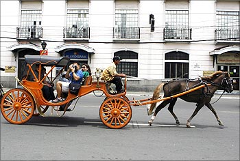 Tourists ride on a 'Kalesa', a horse drawn carriage in Manila.