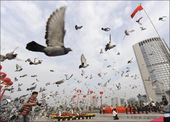 Pigeons are released during a flag raising ceremony to mark the 60th anniversary of the founding of the People's Republic of China.