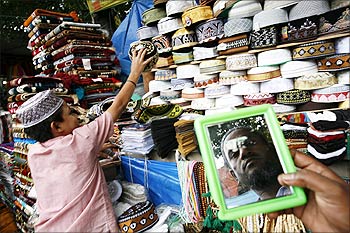 A customer tries on a prayer cap at the new market area in Dhaka.