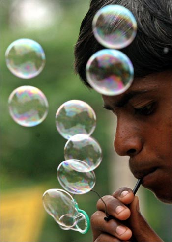 A child blowing bubbles on a street in New Delhi.