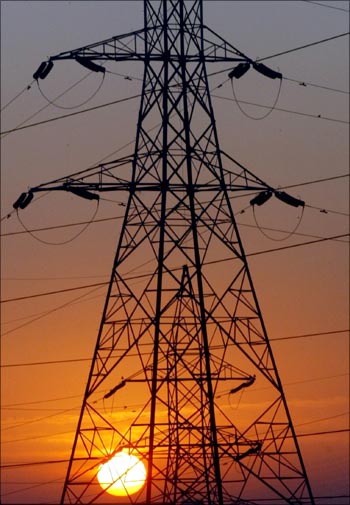 The sun rises behind electric pylons in Ahmedabad.