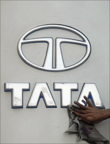 A worker cleans a Tata Motors logo.