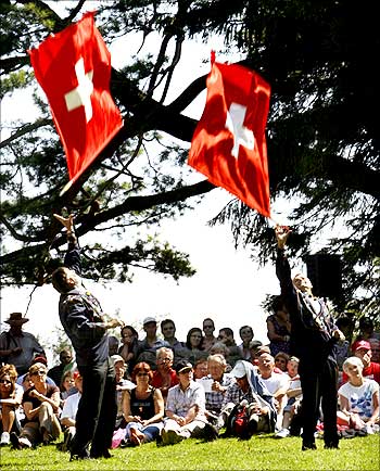 Traditionally dressed men take part in flag tossing during Switzerland's national holiday celebrations.