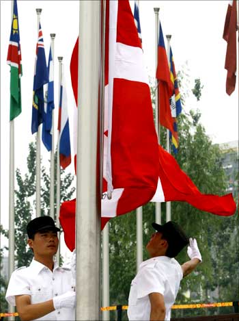 Chinese officials raise the flag of Denmark during the official flag raising ceremony in the Olympic Village ahead of the Beijing 2008 Olympic Games.