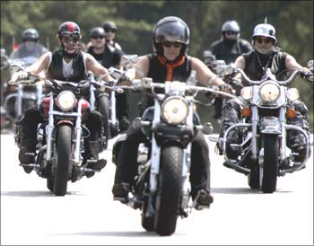 Bikers ride their Harley-Davidsons.