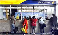 Passengers speak with employees at the Jet Airways ticketing counter at the Mumbai airport.