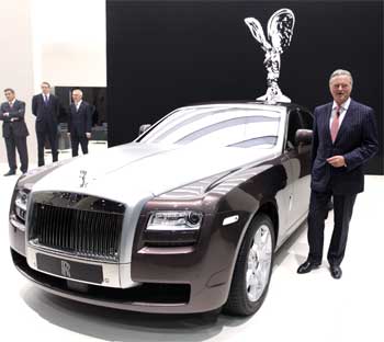 Rolls Royce CEO Tom Purves stands next to a Rolls Royce Ghost.