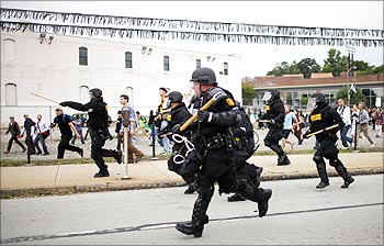 Police officers run to disperse demonstrators during a protest against the G20 Pittsburgh Summit in Pittsburgh.