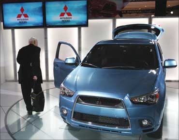 A journalist inspects the 2011 Mitsubishi Outlander sport compact SUV.