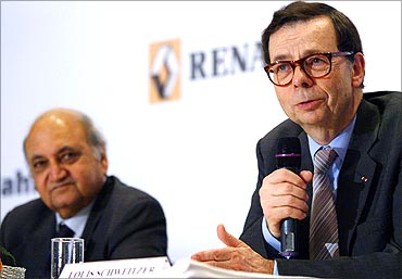 -Renault International chief executive Schewitzer speaks as Keshub Mahindra (L) looks.