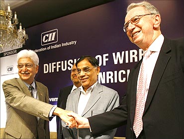 Qualcomm Chairman Irwin Jacobs (R) shakes hands with Wipro Chairman Azim Premji.