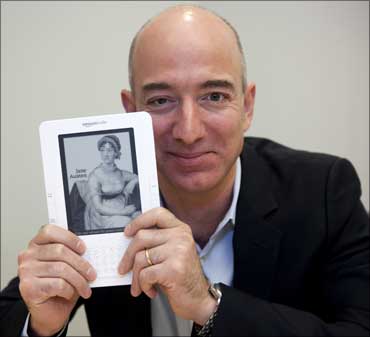 Jeff Bezos, CEO of Amazon.com Inc., shows a Kindle in Cupertino, California.