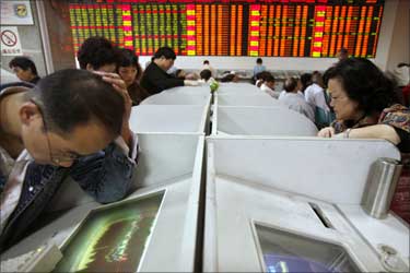 Investors check their stocks value at a stock exchange market in Shanghai.