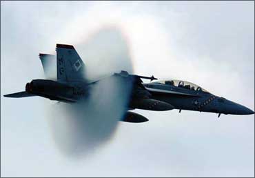 Water vapour builds up around a GE-powered F/A-18F Super Hornet as it breaks the sound barrier.