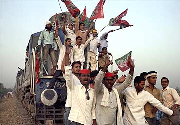 Activists of Samajwadi Party shout slogans after blocking a passenger train.