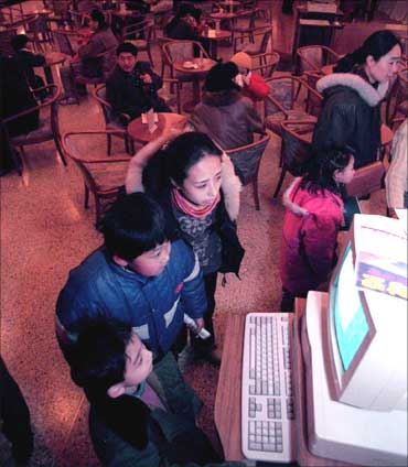Young Beijing residents accompanied by their parents look over what's on offer at China's first cyber cafe way back in 1996.