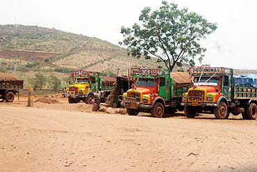 Trucks wait to transport mined ore in Bellary.