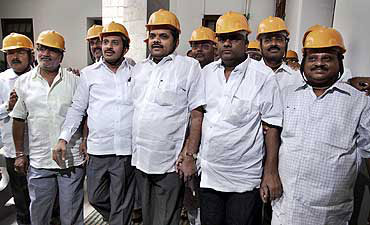 Opposition Karnataka MLAs wear helmets to the assembly to protest against the scam.