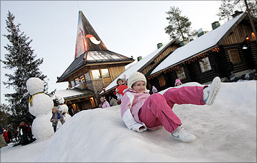 A child slides on the snow in Santa Claus' Village, northern Finland.