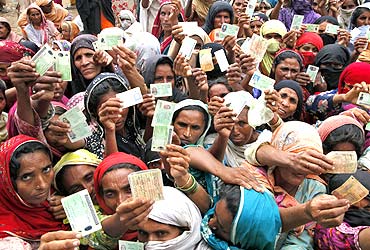 Flood victims show their ID cards to receive food rations at a distribution centre.