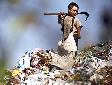 An illegal immigrant boy from Myanmar collects plastic at a rubbish dump site near Mae Sot.