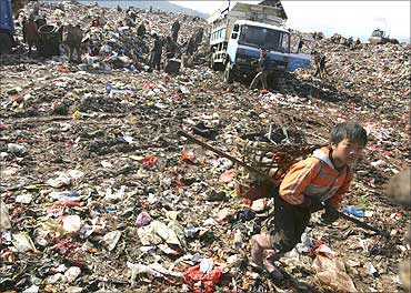 Garbage collectors look for recyclable waste at a garbage dump site in Kunming.