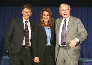 Chairman of Berkshire Hathaway Inc. Warren Buffett (R) poses with Bill and Melinda Gates (C).