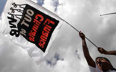 An activist holds a banner during a march in protest against the World Bank's participation in climate finance.