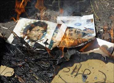 People burn photographs of Lalit Modi, chairman of the Indian Premier League.