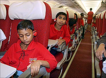Kids sit in a Kingfisher aircraft.