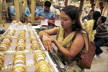 A woman tries on a gold bracelet at a jewellery showroom in Siliguri.