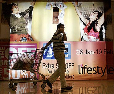 An Indian pulls his trolley as he passes by an advertising display at a shopping mall in Mumbai.