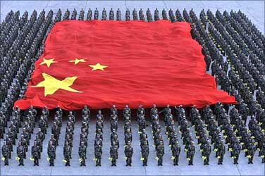 Paramilitary police officers hold a Chinese national flag during a parade training session.