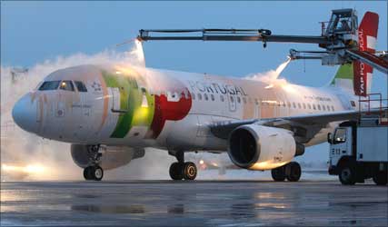 A TAP Portugal plane is being de-iced.
