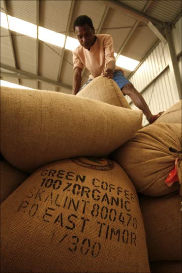 An East Timorese worker moves a sack of coffee at a warehouse outside Dili.
