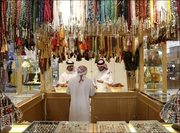 A salesperson shows chaplets to shoppers at Villagio Mall, a popular shopping area in Doha, Qatar.