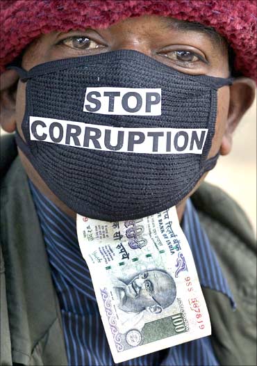 An employee of telecom operator systems, displays an Indian currency note as he takes part in a silent protest against the telecom corruption scandal.