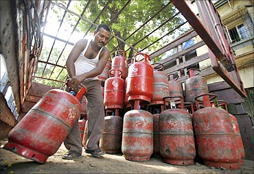 A worker arranges cooking gas cylinders in a truck outside a shop in Mumbai.
