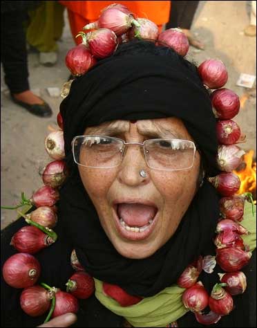 An activist from India's main opposition BJP, wearing a garland made with onions, shouts slogans.