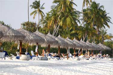 Tourists enjoy the sandy beach of Olhuveli island in Maldives.